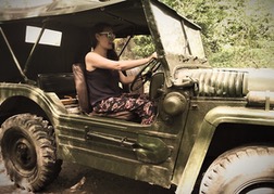 Hen driving a military vehicle